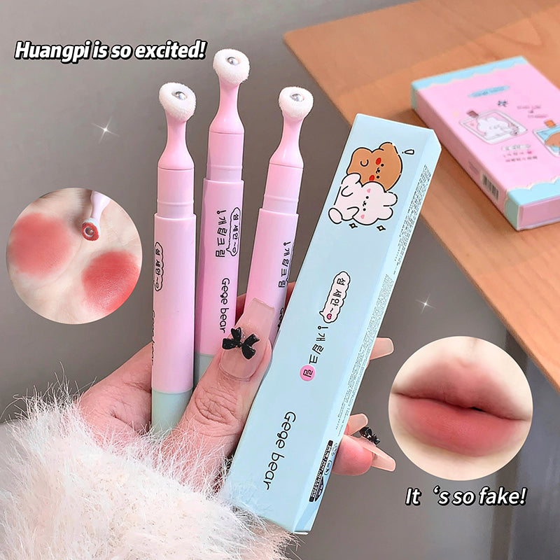 Pink and blue beauty products with a hand holding them, on a wooden surface.