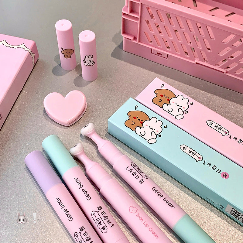 Set of pink and green stationery items with cartoon designs on a gray surface.