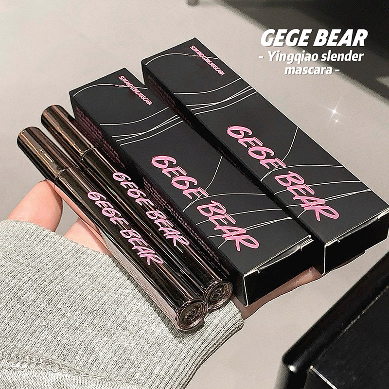 Three 'GEGE BEAR' mascara tubes with their packaging held by a hand on a neutral background.