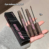 Two GEGE BEAR mascara tubes held by a hand with a black box in the background.