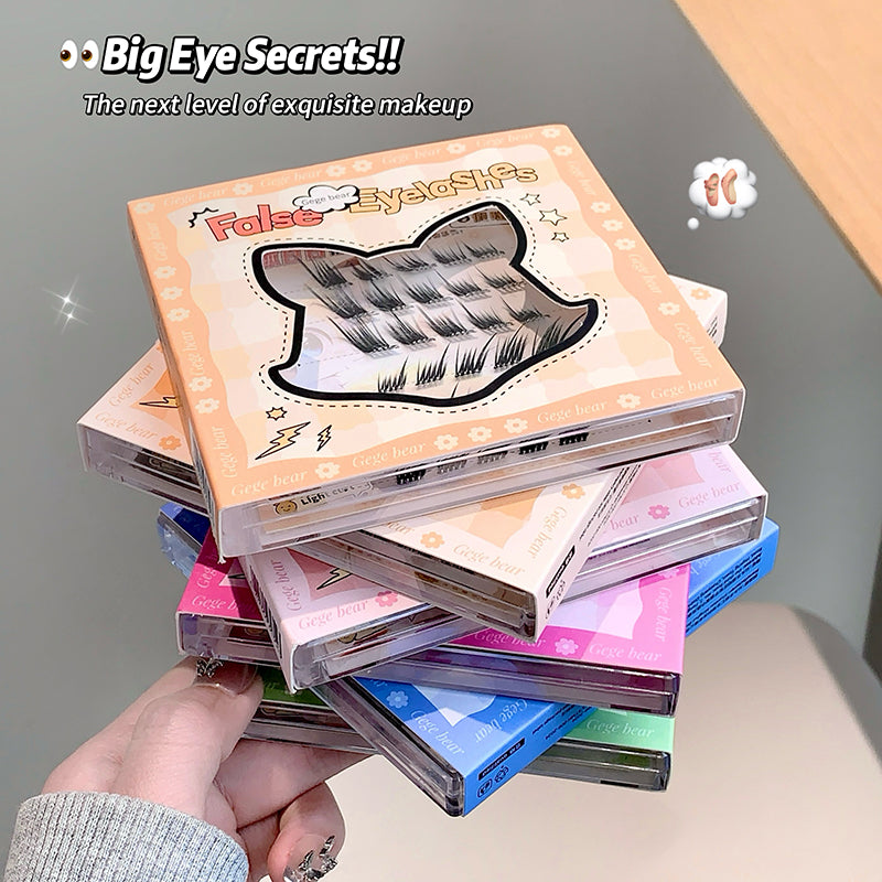 Stack of false eyelash boxes with colorful packaging held by a hand.