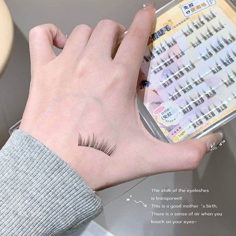 Eyelashes on a hand with a box of false eyelashes in the background