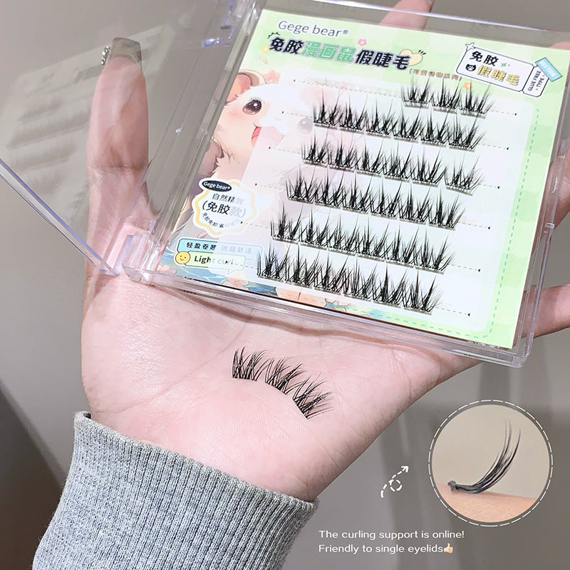 False eyelashes in a packaging box held by a person, with close-up of lashes on hand.