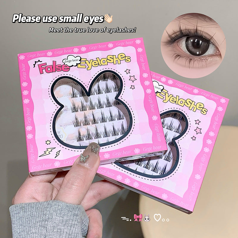 False eyelashes packaging with a hand holding it, and an inset of an eye wearing the false eyelashes.