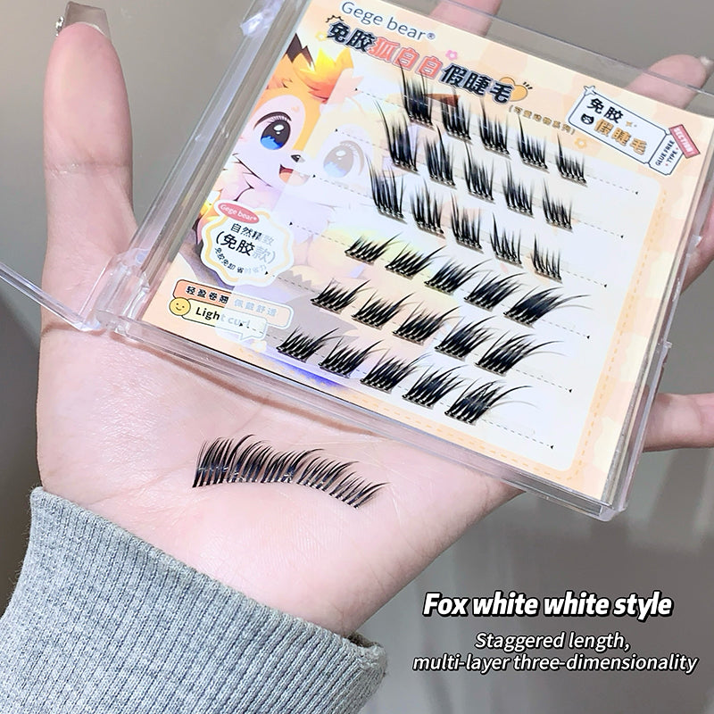 False eyelashes in a box held by a person with an example on their wrist.