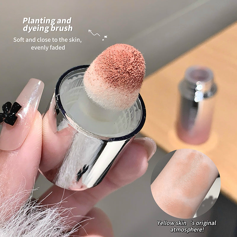 Makeup brush with pink bristle tip held by a hand, with text on plant and dyeing brush.