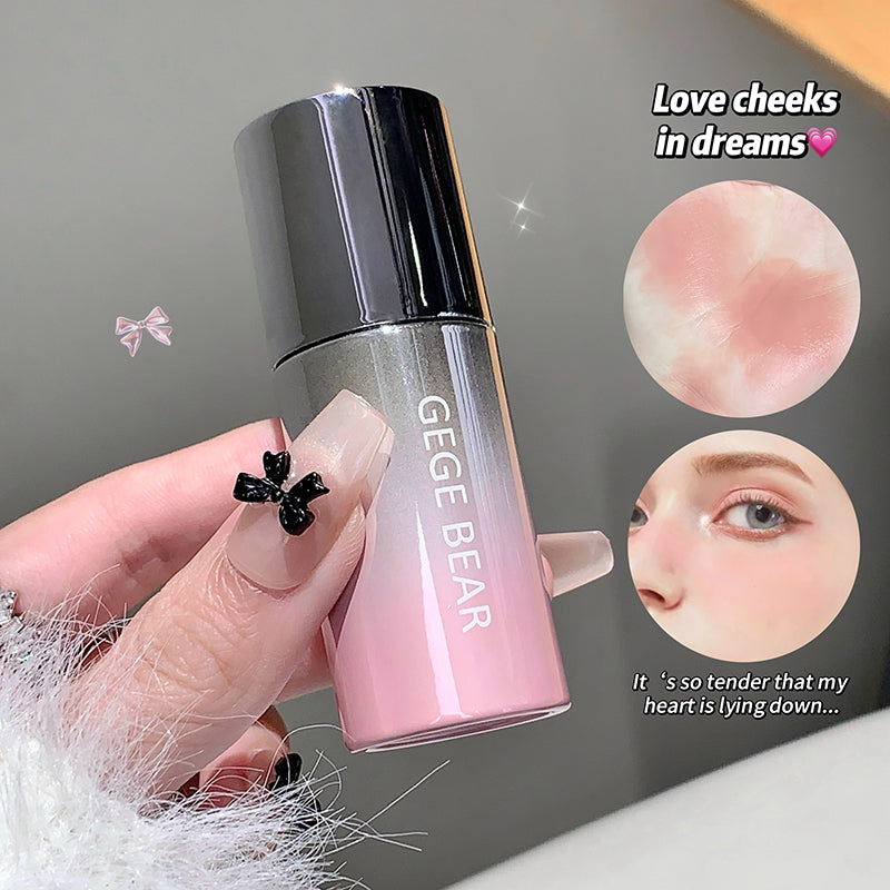 Pink and silver bottle labeled 'GEGE BEAR' held by a hand with decorative nails, against a neutral background.