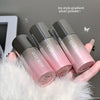 Three GEGE BEAR lip products with gradient silver to pink color on a fluffy white surface.