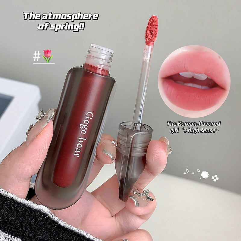Lipstick with applicator held by a hand, close-up of lips, and text overlay on a neutral background