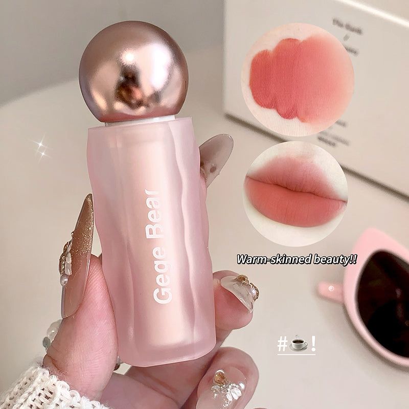 Pink bottle with gold cap held by a hand, with close-up images of lips and a cup in the background.
