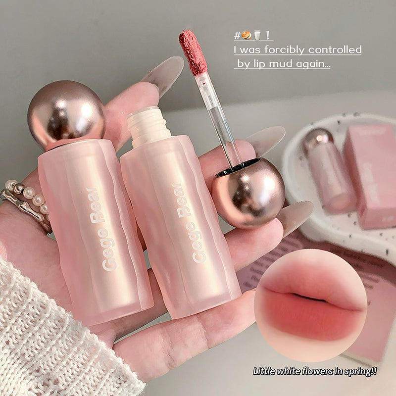 Pink lip balm with applicator held by a hand, close-up of lips, and text overlay on a gray background.