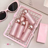 Pink cosmetic products with spherical accents in a pink basket on a light surface.
