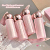 Set of pink lip balms with metallic tops held by a hand on a textured surface.