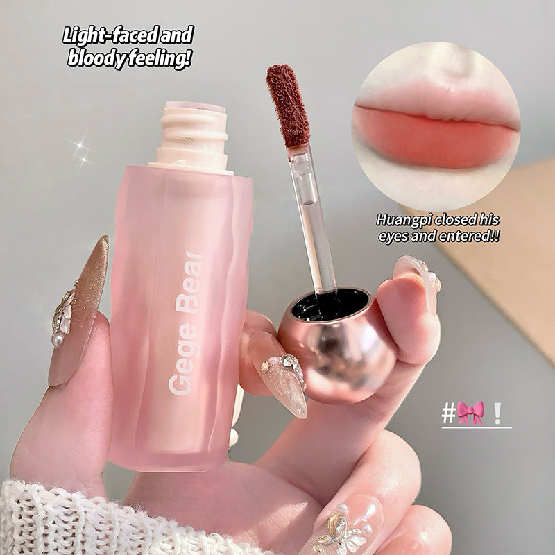 Pink lip gloss with applicator held by a hand, close-up of lip color, and text overlay on a gray background.