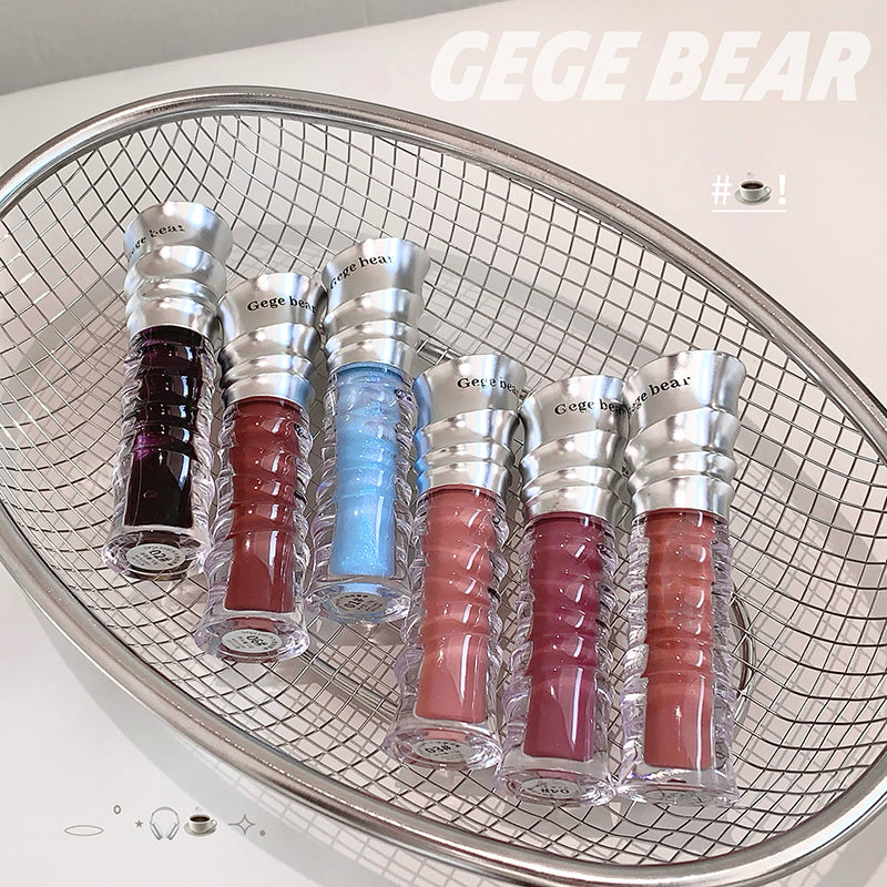 Set of GEGE BEAR lip glosses in various colors displayed on a metal grid.