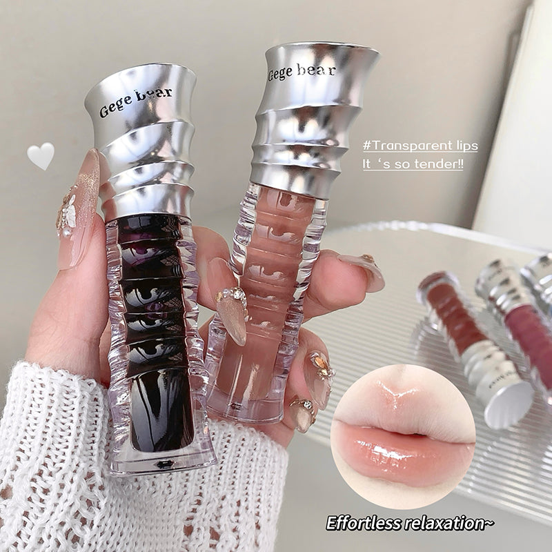Two lip glosses held by a hand with a close-up of lips and product details.