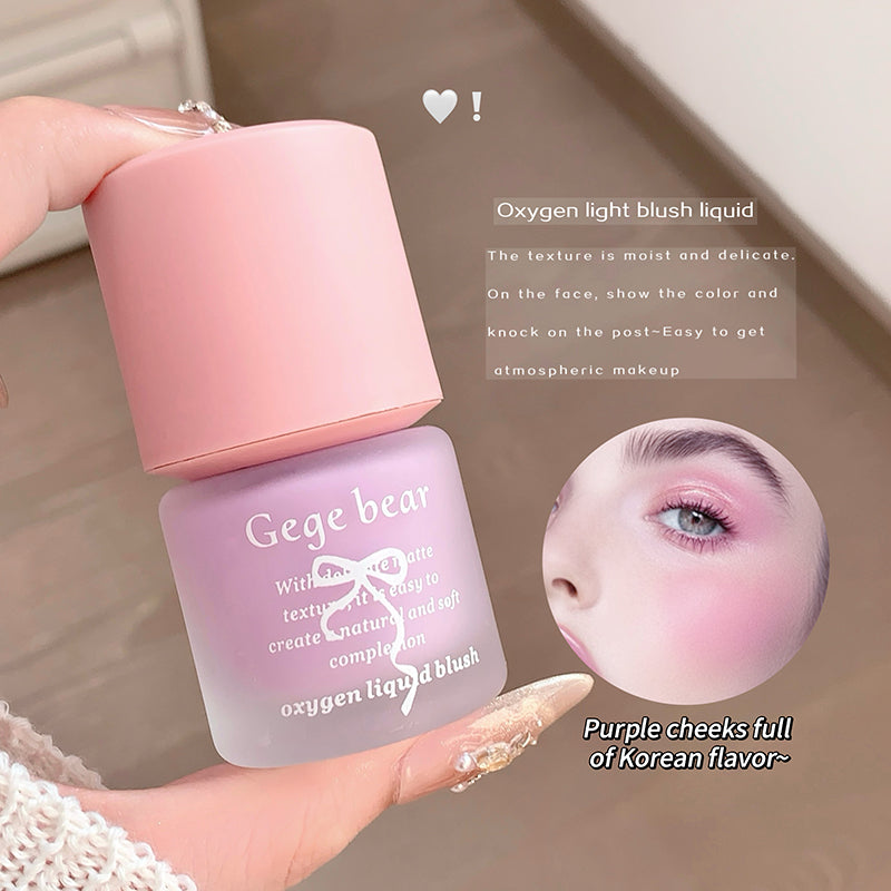 Gege bear oxygen light blush liquid with pink cap and purple body, held by a hand.