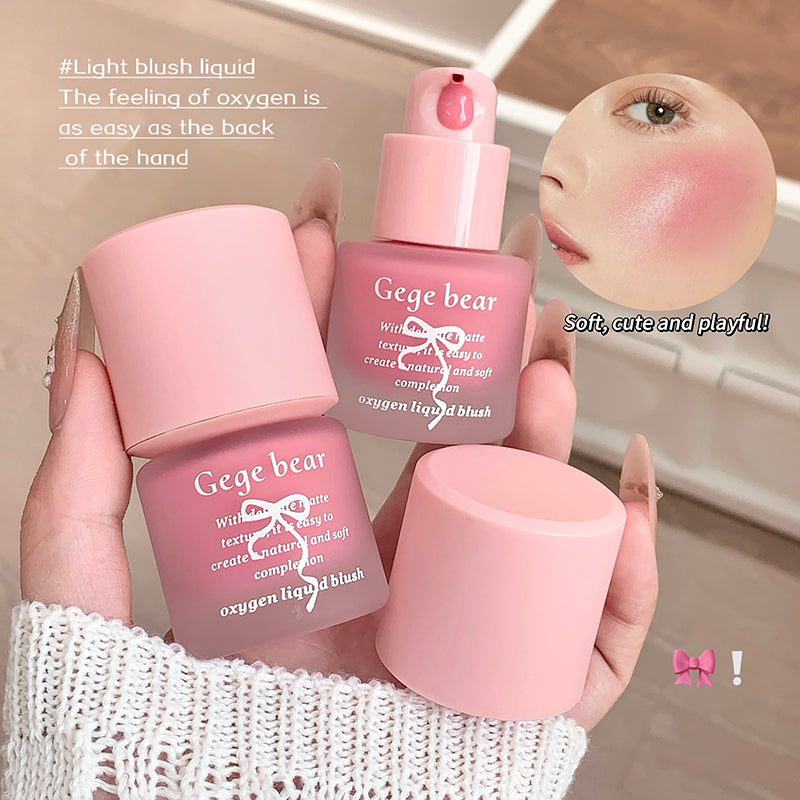 Pink makeup products with 'Gege bear' branding held by a hand, close-up of application on skin.
