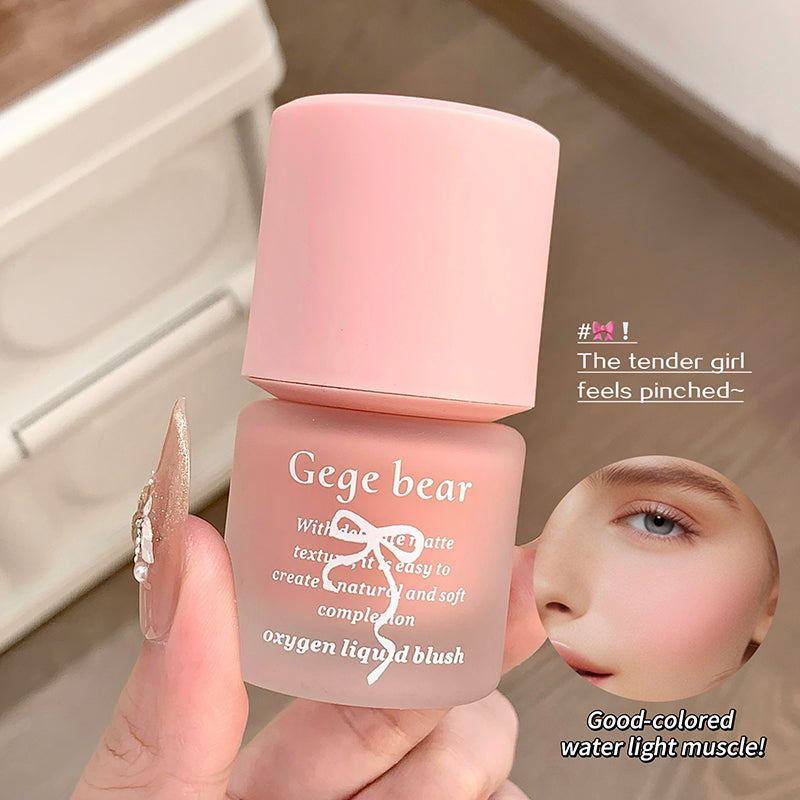 Pink makeup product with 'Gege bear' branding held by a hand, blurred background
