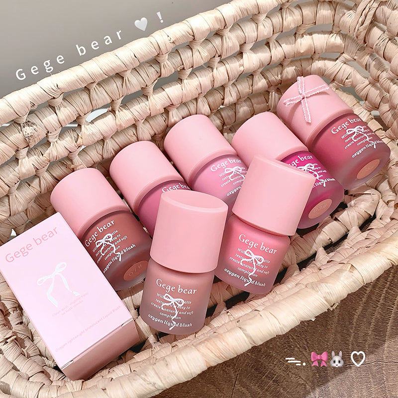 Pink lip products with 'Gege bear' branding arranged in a woven basket.