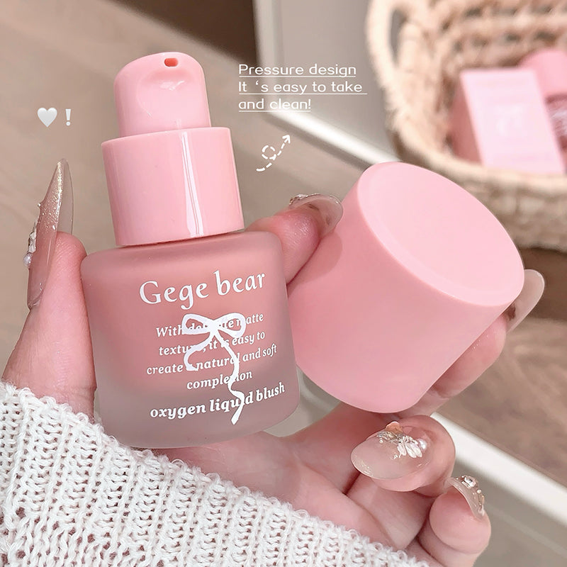 Pink bottle of Gege bear oxygen liquid blush held by a hand with a blurred background