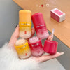 Four lip masks with 'Gege bear' branding held in a hand, one open on a wooden surface.