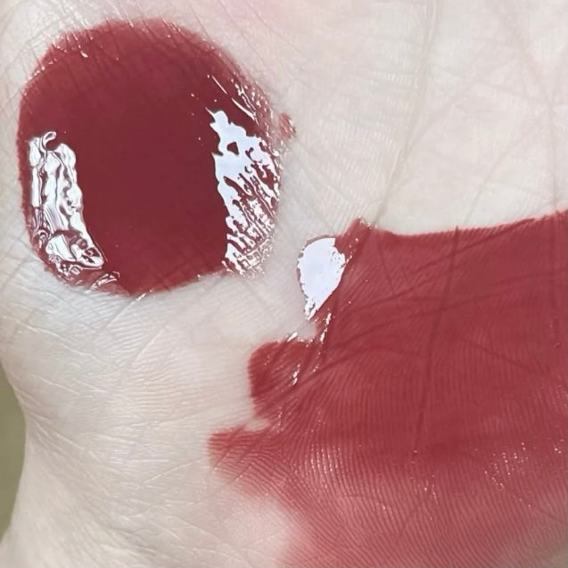 Close-up of red lipstick on a finger with a blurred background