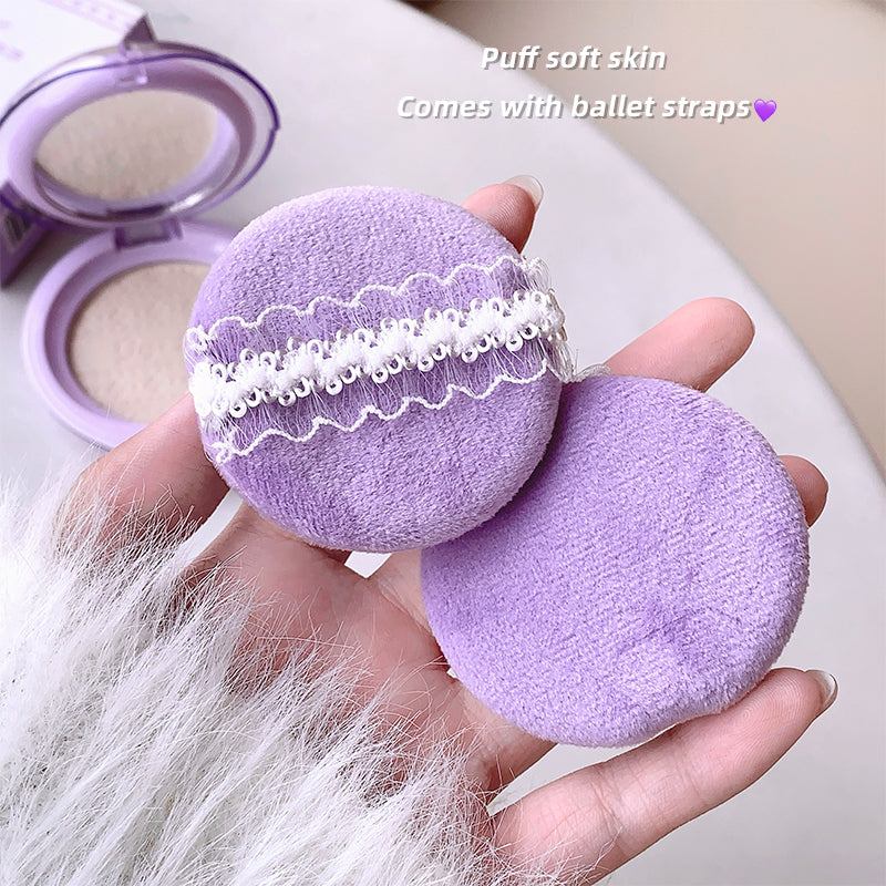 Purple makeup puff held in a hand with text overlay on a neutral background