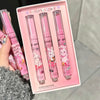 Set of four pink lip balms with cartoon designs in a box