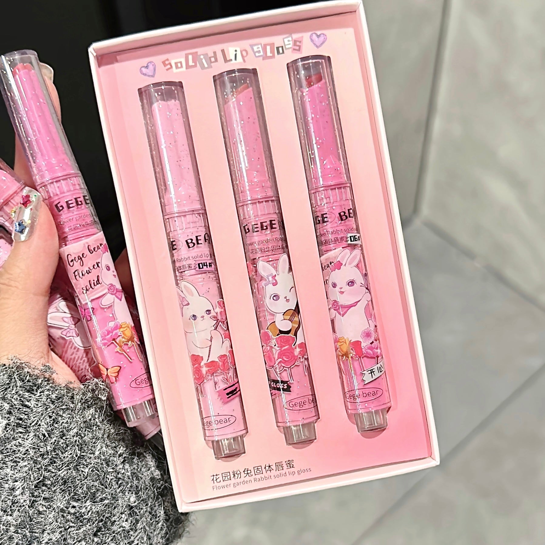 Set of four pink lip balms with cartoon designs in a box