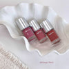 Three bottles of Gege Bear nail polish on a white wavy surface.