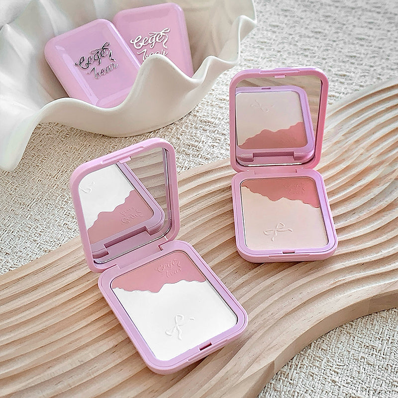 Pink makeup compact with mirror on a wooden surface