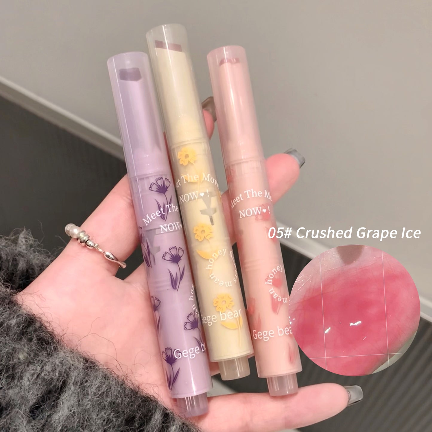 Four lip gloss tubes held in a hand with a close-up of one tube showing '05# Crushed Grape Ice'.