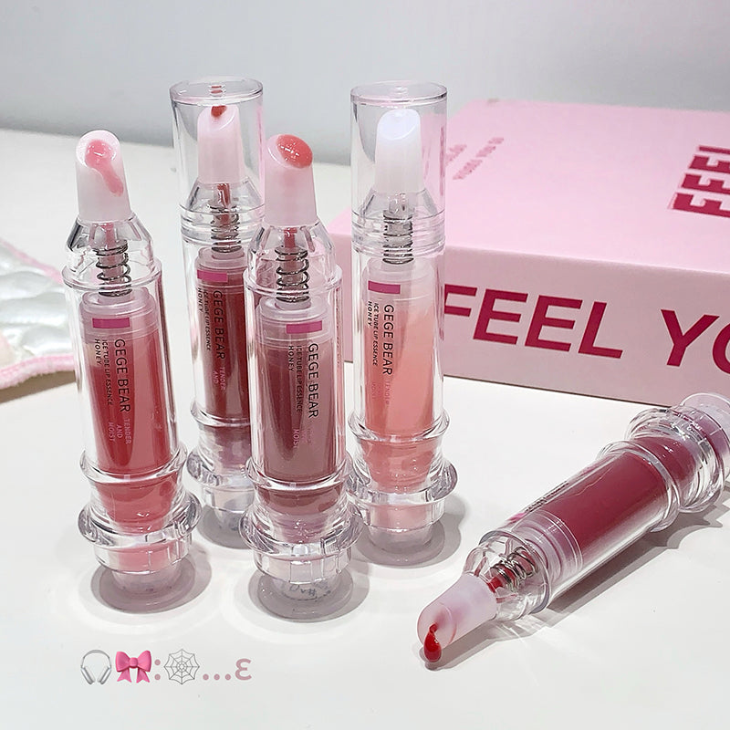 Set of pink lip glosses with clear applicators on a white background, featuring the brand 'GEEGER'.