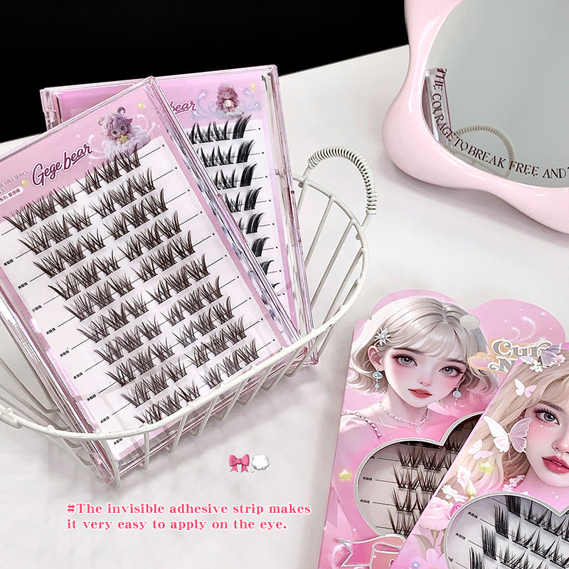 False eyelashes in pink packaging with visible adhesive strip on a white surface.