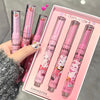 Set of pink lip products with cartoon designs in a box, held by a hand.