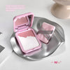 Pink makeup compact with white powder on a silver tray