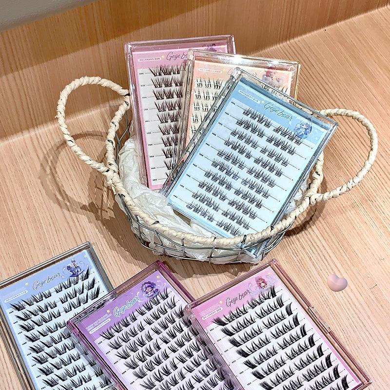 Multiple boxes of false eyelashes on a wooden surface with a woven basket.