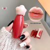 Red lip balm with a white cap held by a hand, close-up of lips with product applied, and additional lip balms in the background.