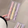Set of three pastel-colored lip balms in a clear packaging on a neutral background.