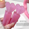 Pink heart-shaped product held by a hand with a soft focus background