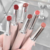 Set of pink lipsticks with silver caps on a reflective surface