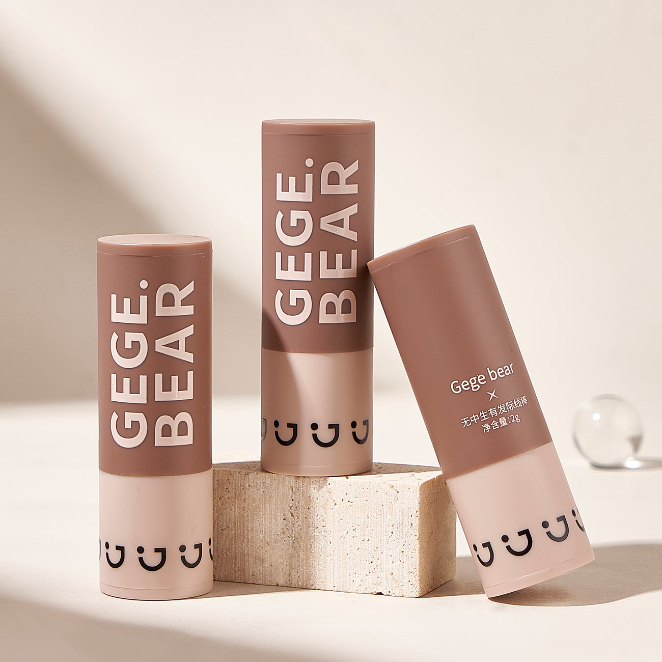 Three Gege Bear lip balm tubes on a light background