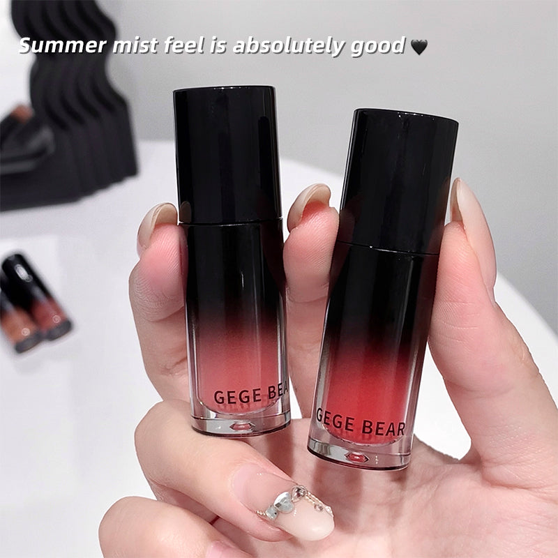 Two lip products with black and red gradient held by a hand, labeled 'GEGE BEAR'.