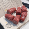 Red lip jelly with 'BEGE' branding on a surface with text underneath