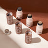 Set of GEGE BEAR cosmetic containers on a brown and beige gradient background