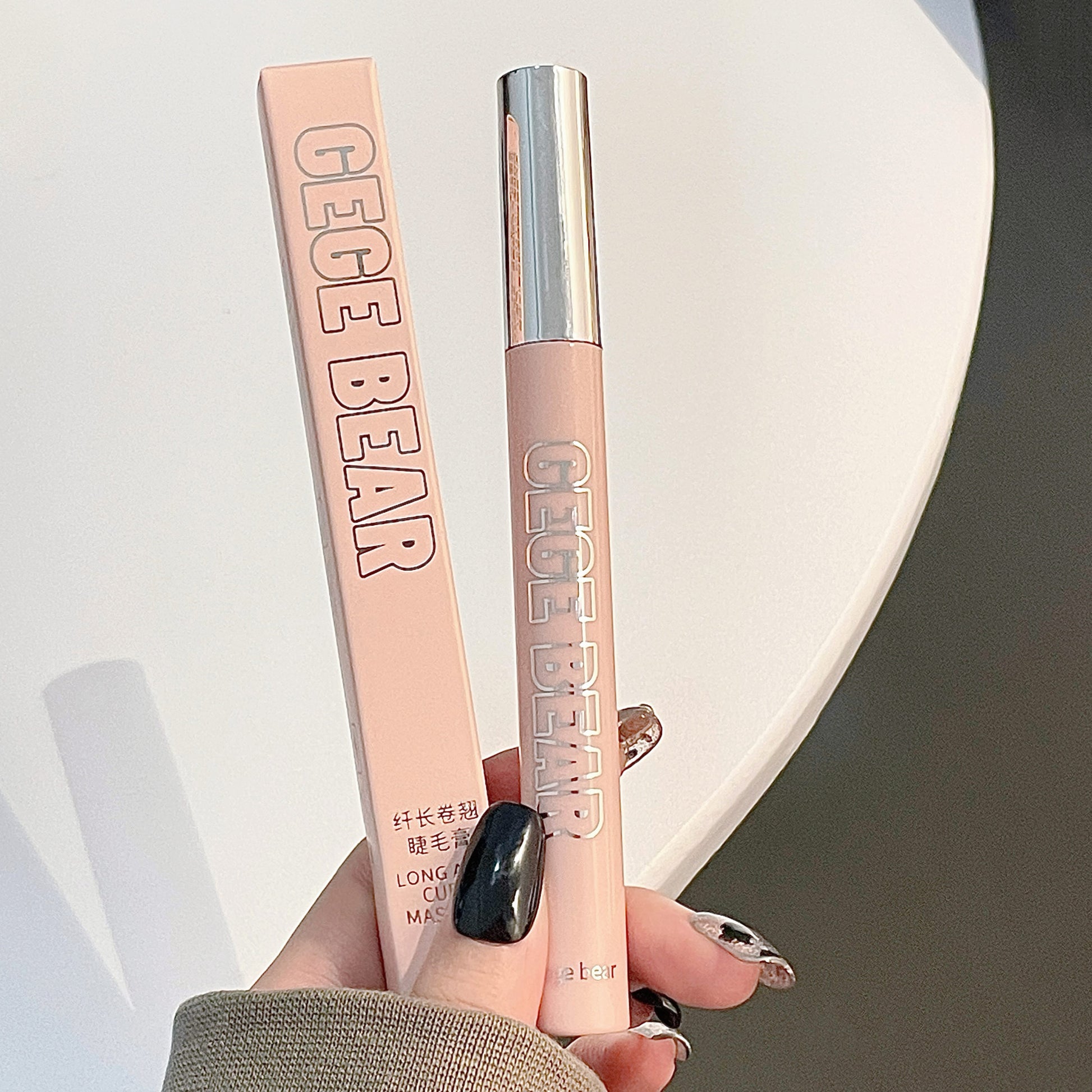Cece Bear makeup product with packaging held by a hand on a neutral background