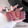 Two lipsticks and two nail polishes held in a hand with a blurred background