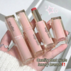 Four Gege bear lipsticks held in a hand with a white background
