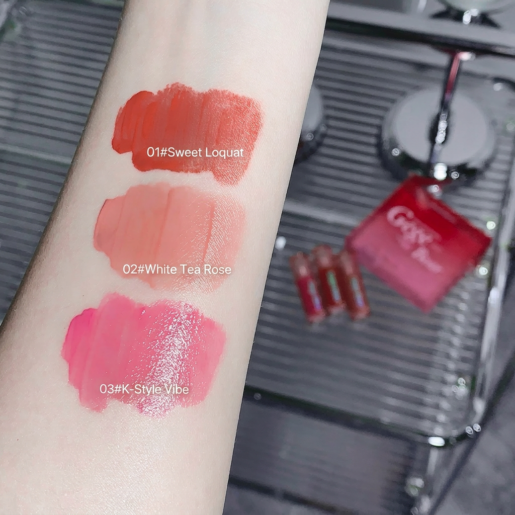 Lipstick swatches on a arm with 'Sweet Loquat', 'White Tea Rose', and 'K-Style Vibe' labels, with a lipstick case in the background.